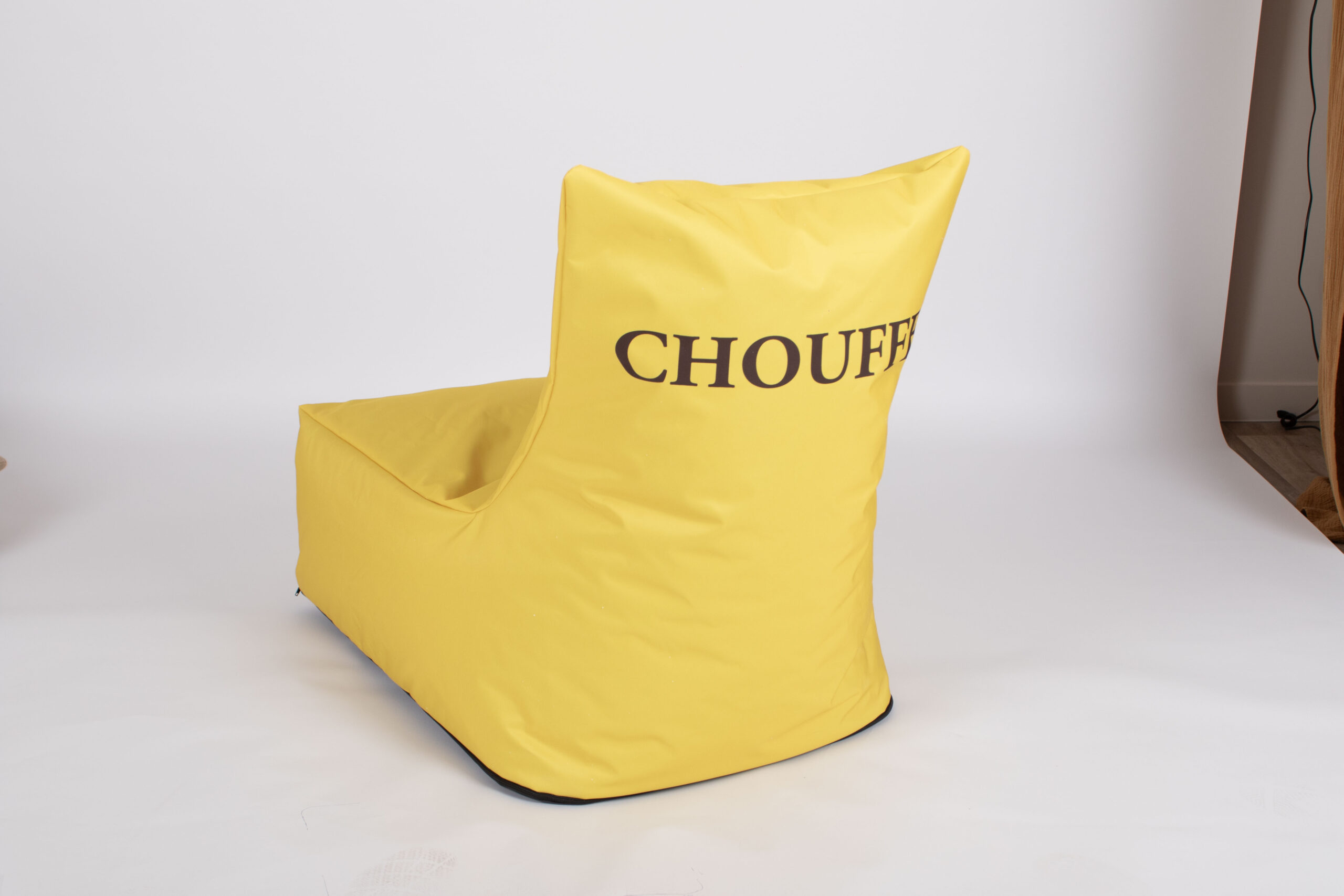 Żółta pufa typu „bean bag” z logotypem Chouffe na jasnym tle.
