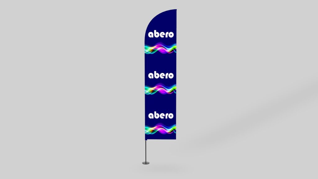 Pionowa flaga reklamowa typu beach flag z granatowym tłem, kolorowymi falami i logotypem Abero, na jasnoszarym tle.