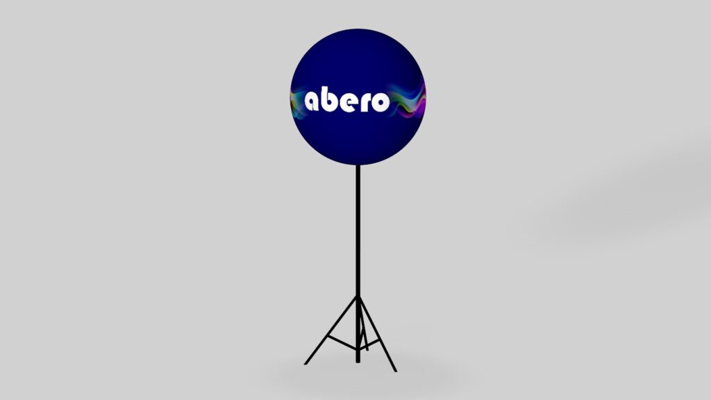 Trójwymiarowy model graficzny okrągłego balonu reklamowego w kolorze ciemnoniebieskim z białym logo abero, zamontowanego na wysokim, czarnym statywie trójnożnym na jasnoszarym tle.