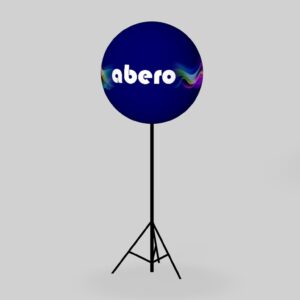 Trójwymiarowy model graficzny okrągłego balonu reklamowego w kolorze ciemnoniebieskim z białym logo abero, zamontowanego na wysokim, czarnym statywie trójnożnym na jasnoszarym tle.