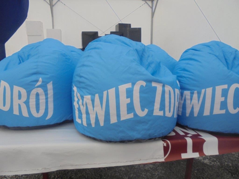 Niebieskie pufy reklamowe typu „bean bag” z wyraźnym białym napisem Żywiec Zdrój.