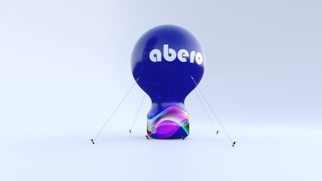 Pneumatyczny balon reklamowy typu Talio z wyraźnym logo "abero" na granatowej czaszy; model prezentowany jest na jasnym tle, posiada zintegrowany system nadmuchowy oraz odciągi stabilizujące, co pozwala na bezpieczną ekspozycję marki w przestrzeni publicznej.